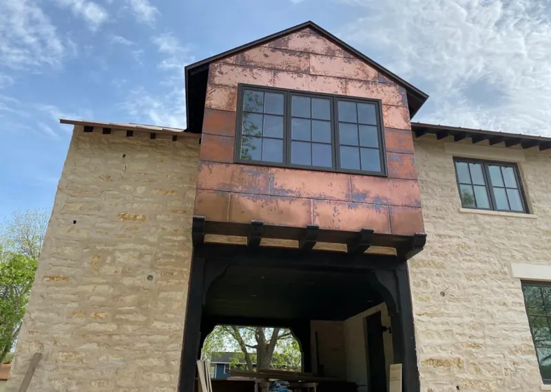 Copper metal panel facade on a stone building for Roof Repair in Owasso